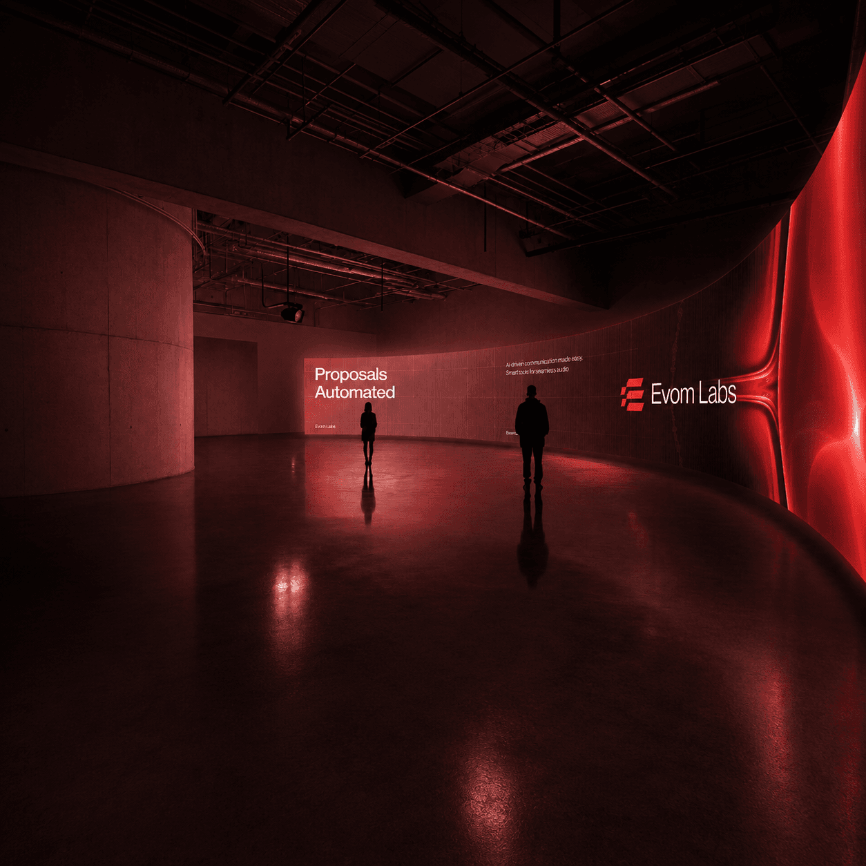 An Evom Labs installation: two people in front of a curved wall lit in red, carrying the Evom Labs wordmark